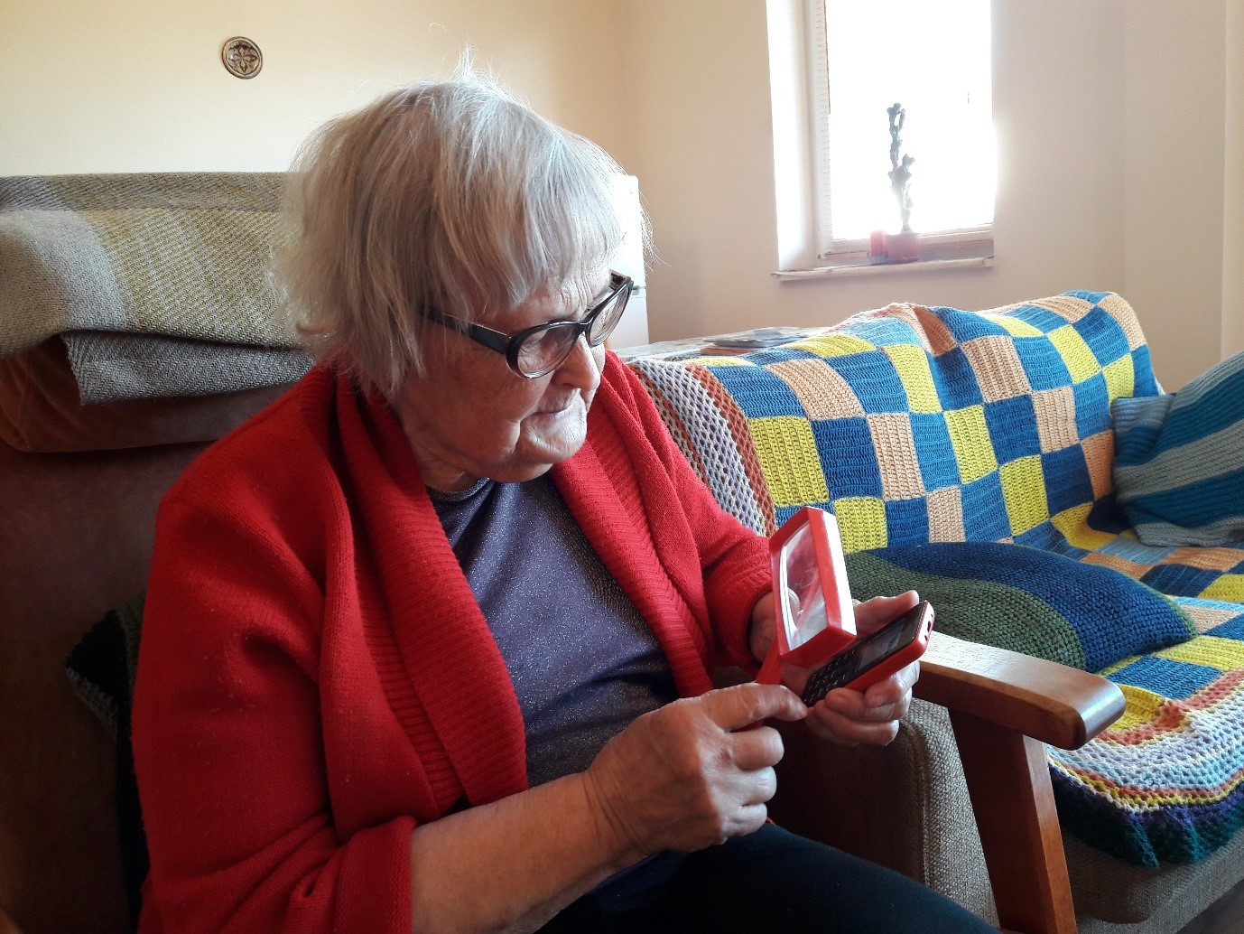 Foto 1. Minu vanaema uurimas enda väikese UI-ga mobiiltelefoni